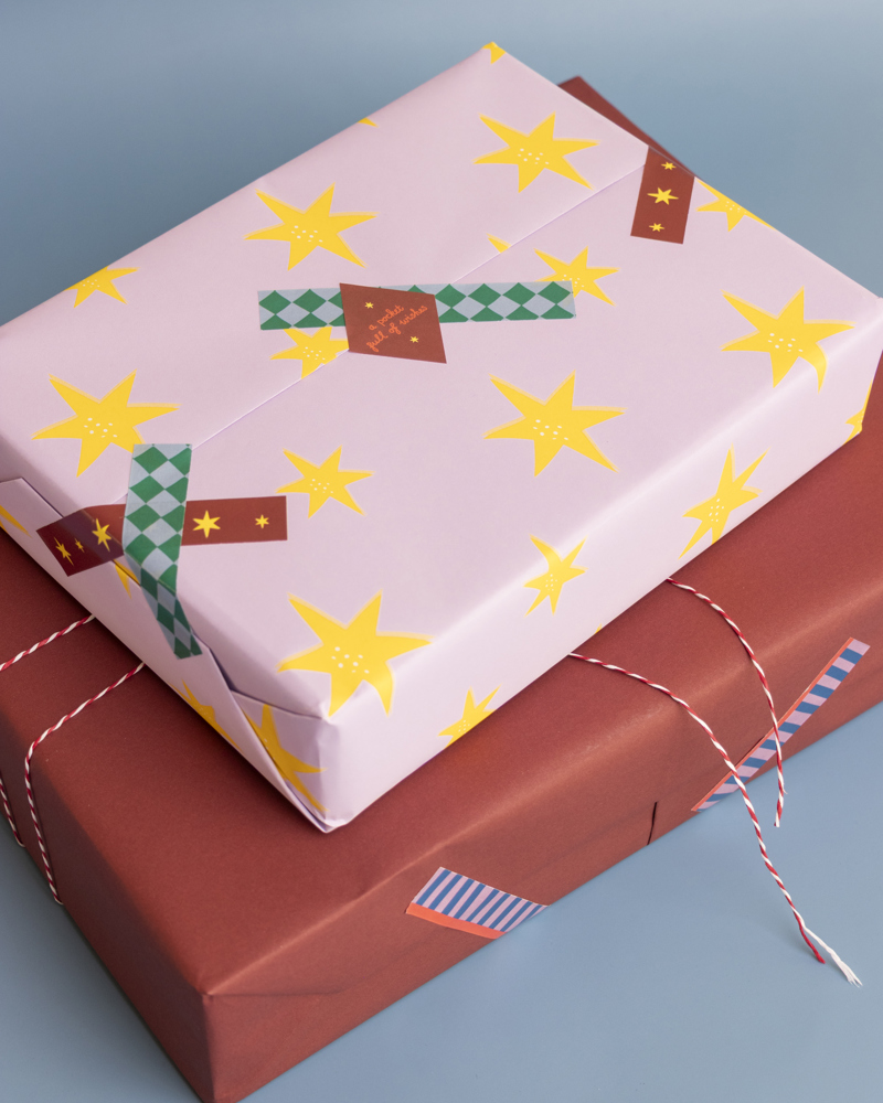 Twee ingepakte cadeaus; één met een lichtroze verpakking met sterren en één in rode verpakking met een touwtje erop.